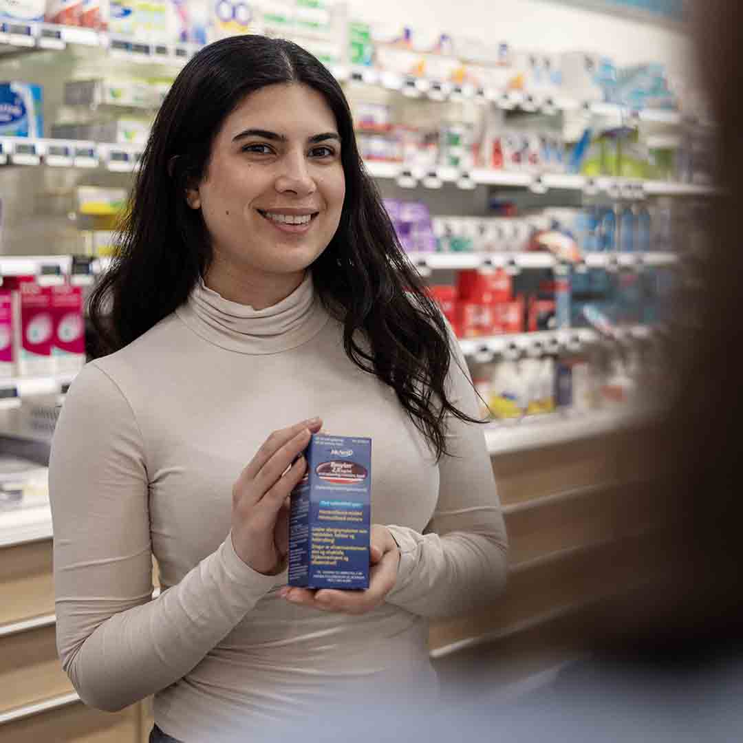 The employee from the pharmacy in Frederiksberg shows medicine. 